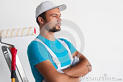 Confident painter near roller and ladder Stock Photo