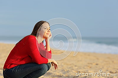 Confident pensive woman thinking on the beach Stock Photo