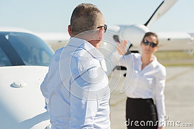 Confident pilot with stewardess and private jet Stock Photo