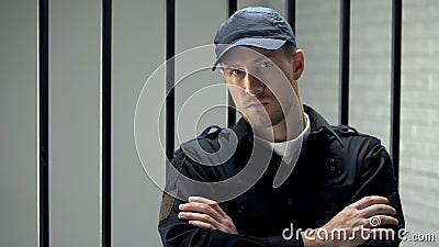 Confident prison security guard looking to camera standing near cell, profession Stock Photo