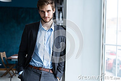 Confident professional handsome businessman standing near window in his office Stock Photo