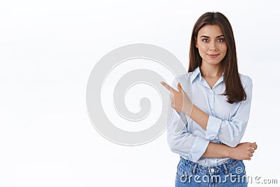 Confident professional young woman in blue blouse pointing finger upper left corner and looking at camera persuade Stock Photo