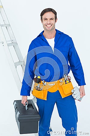 Confident repairman carrying tool box Stock Photo