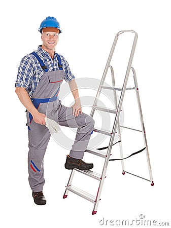 Confident repairman with ladder Stock Photo