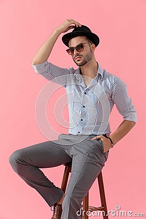 Confident smart casual man fixing his hat Stock Photo