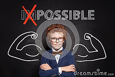 Confident smart kid with text possible on chalkboard background. Success and develop concept Stock Photo