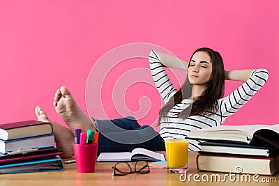 Confident student with her legs crossed up on the table, dreaming Stock Photo