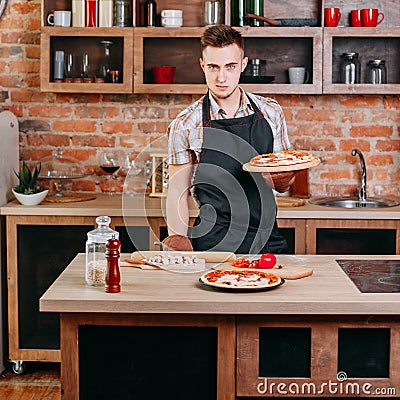 Confident young man with fresh baked pizza Stock Photo