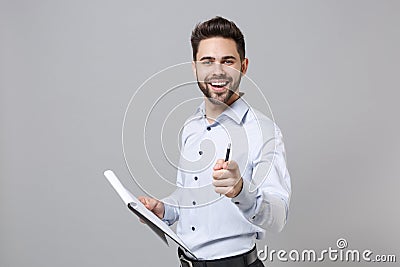 Confident young unshaven business man in light shirt isolated on grey background. Achievement career wealth business Stock Photo