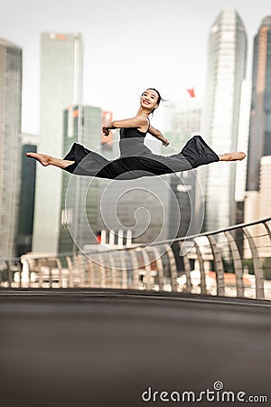 Confident Young Woman Athlete performs a perfect split leap high Stock Photo