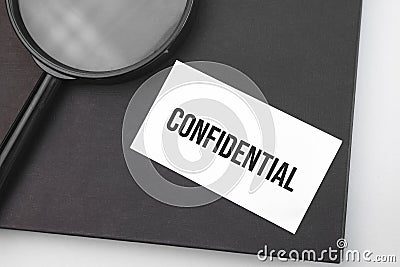 Confidential word on paper and magnifying lens Stock Photo