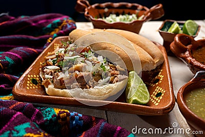 Confit pork sandwich called Torta de carnitas on white background. Mexican food Stock Photo