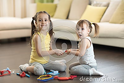 Conflict between little sisters. Kids are fighting, toddler girl takes toy, sibling relationships Stock Photo