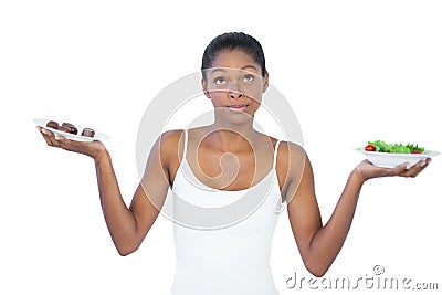 Conflicted woman deciding to eat healthily or not Stock Photo