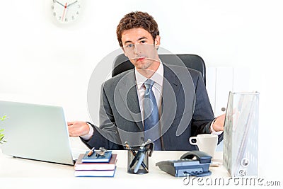 Confused business man sitting at office desk Stock Photo