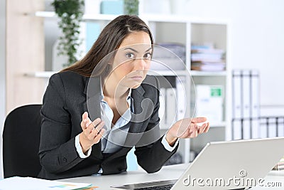 Confused businesswoman looking camera with laptop at office Stock Photo