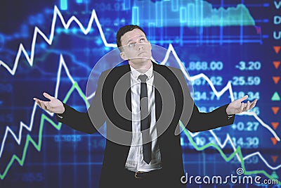 Confused caucasian businessman with declining business charts Stock Photo