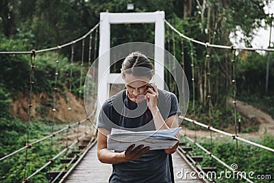 Confused Caucasian man looking at a map travel and explore concept Stock Photo