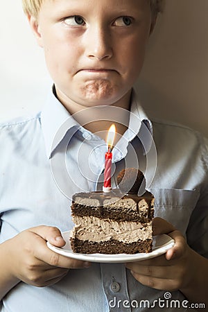 Confused child with birthday cake Stock Photo