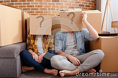 Confused couple of having to move and arrange all the packages. Concept of success, delusion, change , future, confusion Stock Photo