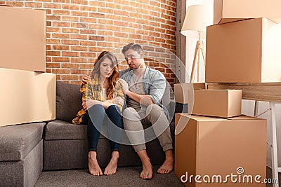 Confused couple of having to move and arrange all the packages. Concept of success, delusion, change and future Stock Photo
