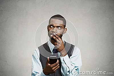 Confused executive thinking how to reply to message on smart phone Stock Photo