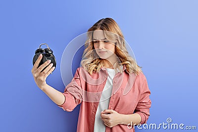 confused female teen look at clocks with dissapointment, need more time Stock Photo