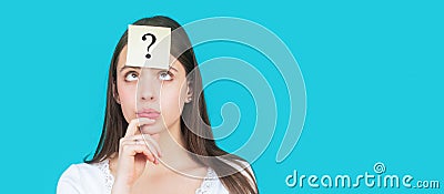 Confused female thinking with question mark on sticky note on forehead. Thinking woman with question mark looking up Stock Photo