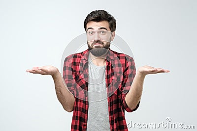 Confused hispanic man giving I dont know gesture on white background. Stock Photo