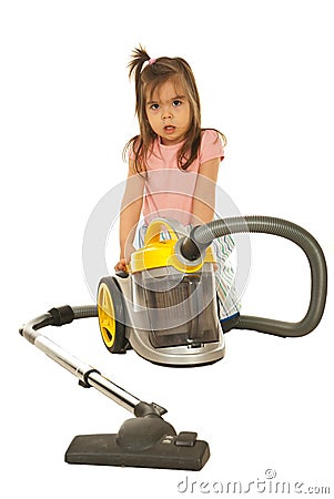 Confused little girl with vacuum cleaner Stock Photo