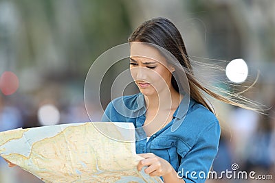 Confused lost tourist reading a map searching location Stock Photo