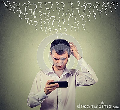 Confused man looking at his mobile smart phone has many questions Stock Photo