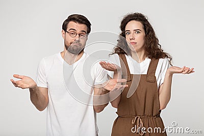 Confused millennial couple shrug shoulders feel baffled Stock Photo