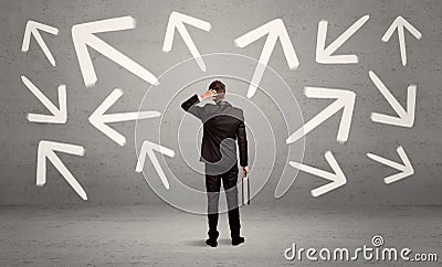 Confused salesman with arrows on wall Stock Photo