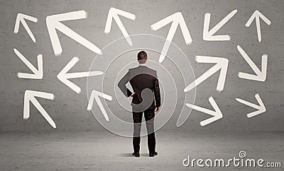 Confused salesman with arrows on wall Stock Photo