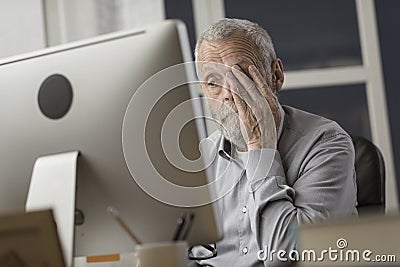 Confused senior citizen using a computer Stock Photo