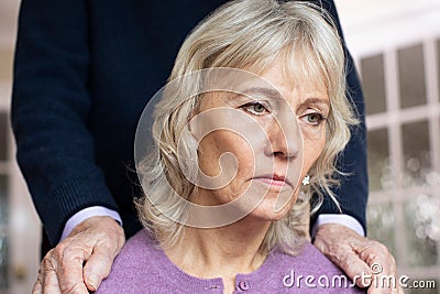 Confused Senior Woman Suffering With Depression And Dementia Being Comforted By Husband Stock Photo