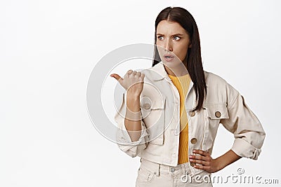 Confused and shocked adult woman, pointing and staring at left side sale logo, showing shocking event announcement Stock Photo
