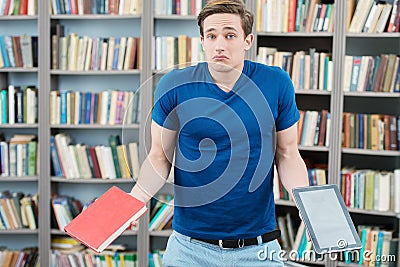 Confused student trying to choose between book and Stock Photo