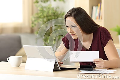 Confused woman comparing on line information Stock Photo