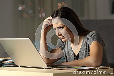 Confused woman working online late hours Stock Photo