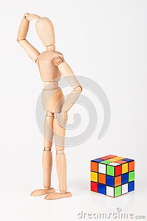 Confused wood mannequin stand next to puzzle confused before attempt to solve Stock Photo