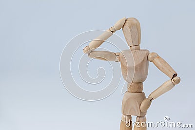 Confused wooden figurine standing with hand on head Stock Photo