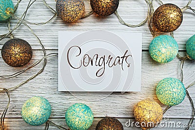 Congrats text on paper card with LED cotton balls top view on wooden background Stock Photo