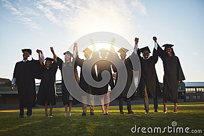 Congratulations are in order. a group of university students standing together on graduation day. Stock Photo