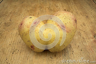 Conjoined potato on a wooden kitchen table with copy space Stock Photo