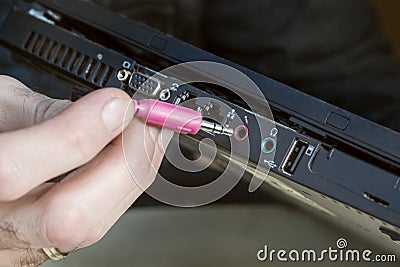 Connecting the red cinch plug to the microphone jack on the laptop Stock Photo