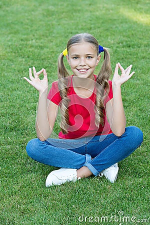 Connecting to your higher self. Happy child keep hands in mudra. Little girl meditate on green grass. Mudra of Stock Photo