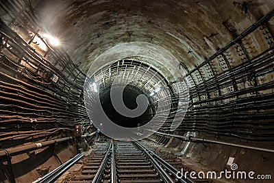 The connection of a reinforced concrete tunnel with a cast-iron tunnel. The light is on. The connection of two metro railway track Stock Photo