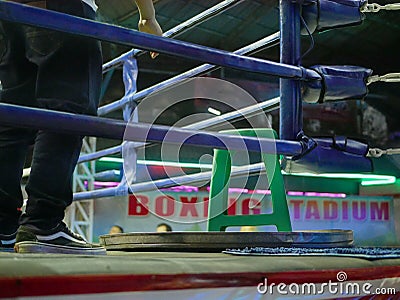 A connerman standing inside a boxing ring trainer / coach waiting to assist and administer to the fighter during a bout / Stock Photo